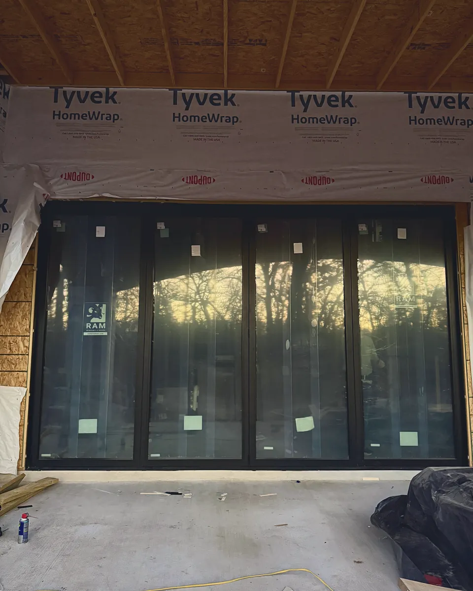 Custom four-panel door, with every panel operable, installed in a newly framed, widened wall opening