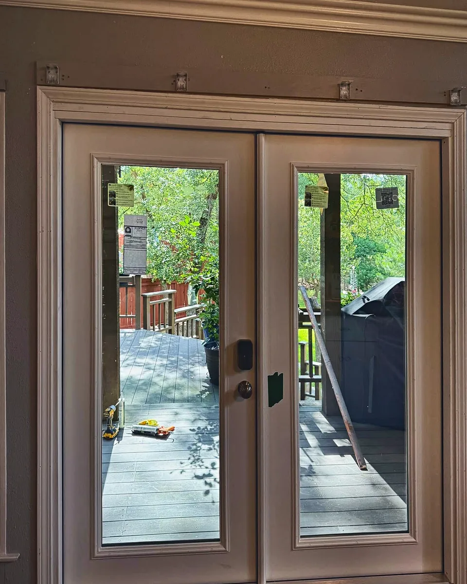 White full-glass French doors opening onto a backyard deck